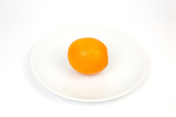 Orange on a white plate on a white backdrop.