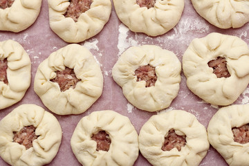 Preparation of belyashes. Traditional russian meat pies belyashi. belyashes on a table. Russian, Bashkir and Tatar cuisine. Top view.