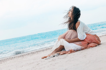 Fototapeta na wymiar beautiful young stylish woman in pink skirt on the beach