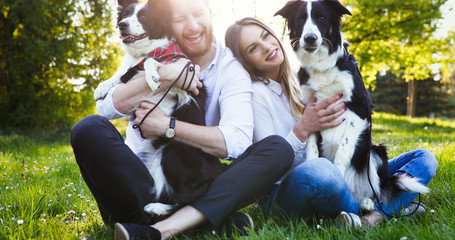 Beautiful couple cuddling and walking dogs outdoors