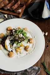 salad with pear, mozzarella in batter, with blue cheese sauce, cashew nuts and lettuce leaf and decanter of red wine