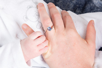 newborn baby hand on mother hand, holding hands with love