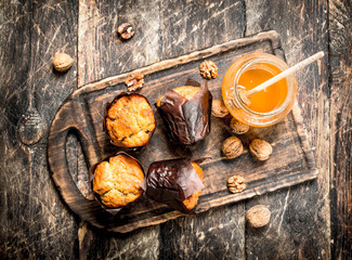 Muffins with honey and nuts on the board.