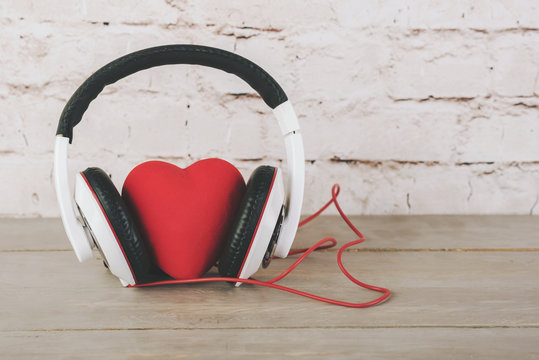 San Valent&iacute;n, coraz&oacute;n con auriculares sobre una mesa de madera