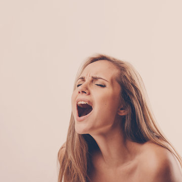 portrait of a young woman during an orgasm on a white background