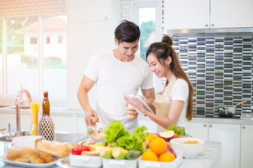 Asian couple cooking for bakery for romantic diner in kitchen room in the home.
