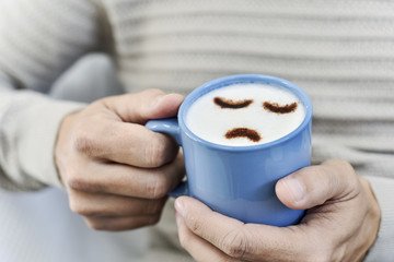 man with a cup of cappuccino with a sad face