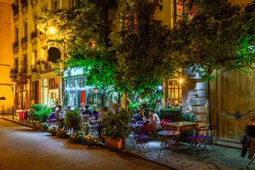 Zelfklevend Fotobehang Cozy street with tables of cafe in Paris at night, France © Ekaterina Belova