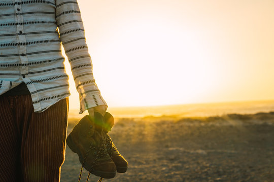 Crop man showing trekking boots in sunlight