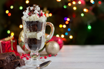 Christmas background-homemade chokolate  dessert with wipped creame  , Christmas decoration on white wooden table on background of  bokeh lights