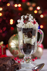 Christmas background-homemade chokolate  dessert with wipped creame  , Christmas decoration on white wooden table on background of  bokeh lights