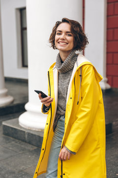 Portrait of happy joyful woman walking through street talking on her cell phone being satisfied with good news