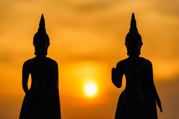 Silhouette buddha statues on blurred sunset background.Thailand.