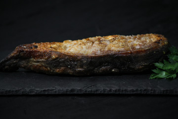 fried fish steak on a slate plate