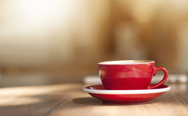 Red Cup of coffee on wooden table