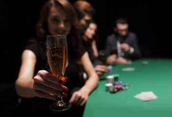 fashion woman with glasses of wine,sitting at a table in a casino