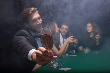 poker player raising a glass of wine