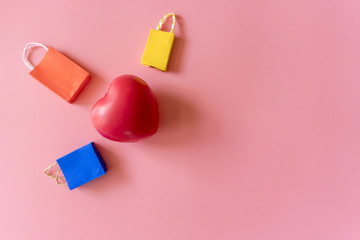 Minimal shoping online concept, Colorful paper shopping bag go down from floating pink background for copy space. Customer can buy everthing form home and the messenger will deliver.