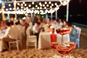 Pyramid from glasses of red wine on wedding party. Close-up of the pink champagne or wine pyramid in ceremony party.