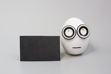 Easter Egg With Face with black blank card mockup copy space. Concept Easter Background