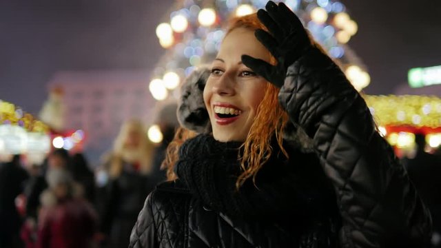 Happy smiling tourist red hair young girl walking at winter fair and wondering
