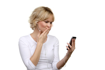 H&uuml;bsche blonde Frau mit Kopfh&ouml;rern schaut in ihr Smartphone Display und wirft einen Luftkuss