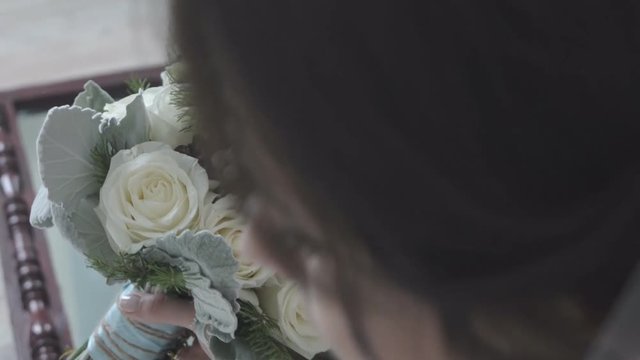 Bride smelling bouquet of flowers 