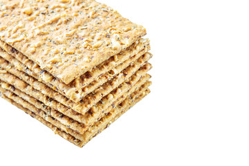 Stack of crispy wheat flatbread crackers with seeds isolated on a white background
