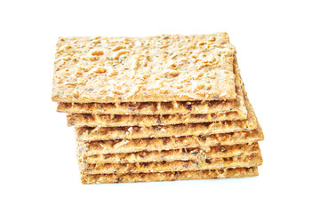 Stack of crispy wheat flatbread crackers with seeds isolated on a white background