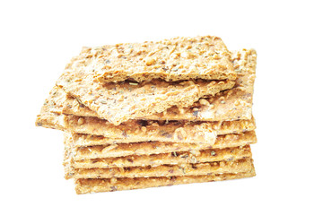 Stack of crispy wheat flatbread crackers with seeds isolated on a white background