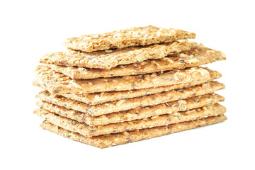 Stack of crispy wheat flatbread crackers with seeds isolated on a white background