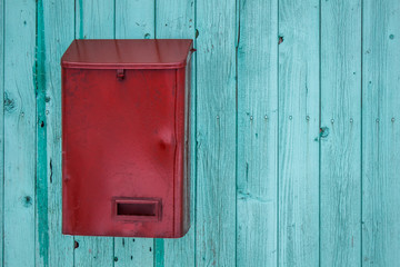 Red mail box on blue wooden wall