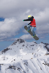 Naklejka na ściany i meble Flying snowboarder on mountains. Extreme winter sport.