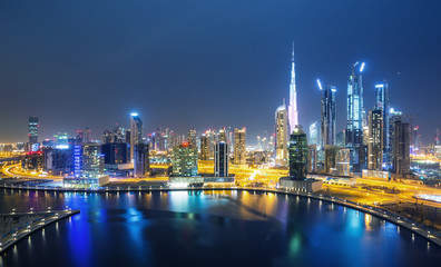 Fototapeta na wymiar Dubai skyline and water canal with promenade after the sunset, Dubai,United Arab Emirates