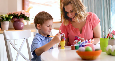 Fototapeta na wymiar Mother and son paint Easter eggs
