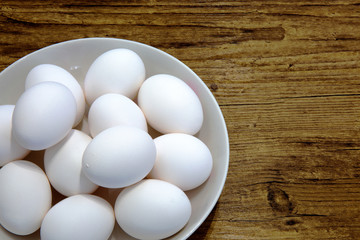 White eggs in white bowl isolated close up. Real white eggs Easter food background.