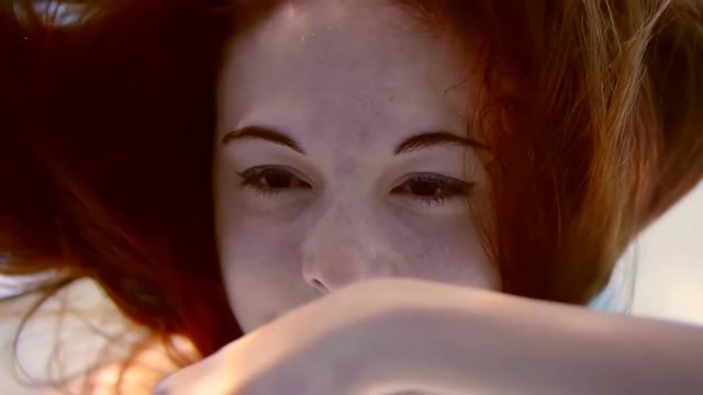 close-up. portrait of red hair girl underwater