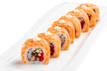 sushi rolls with salmon, eel, cucumber and tobiko on white plate