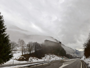 medieval castle among low winter clouds, Mesocco, Switzerland