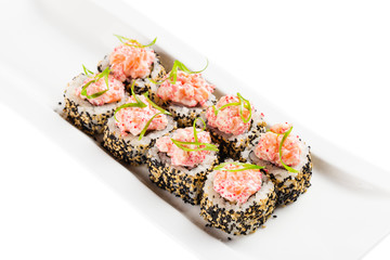 Uramaki sushi roll with japanese mayonnaise and tobiko covered with sesame seeds