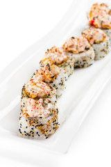 Uramaki sushi roll with japanese mayonnaise and tobiko covered with sesame seeds