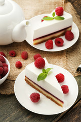 Tasty raspberry cheesecake in plate on wooden table