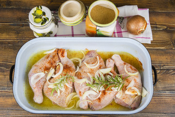 Raw chicken thighs in the pan with onions