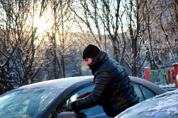 winter man brush car snow