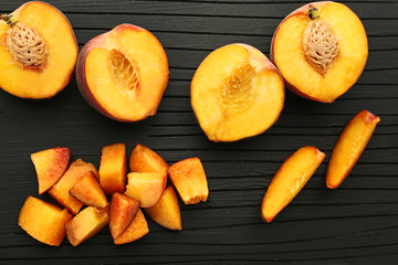 Slices of sweet nectarines fruit on black cutting board