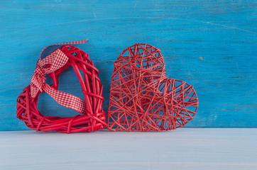 Happy Valentine's day/two red wicker hearts on blue rustic background with copy space