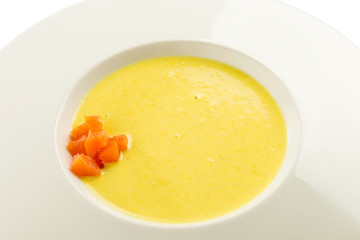 Cheese cream soup with salmon on white plate isolated on white