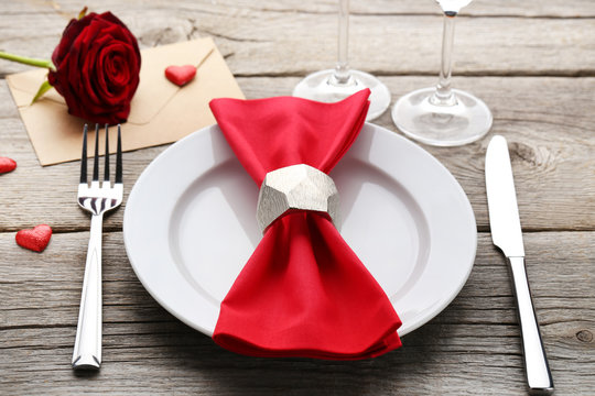 Red Napkin In Plate With Fork And Knife On Wooden Table