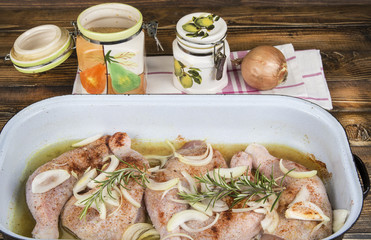 Raw chicken thighs in the pan with onions
