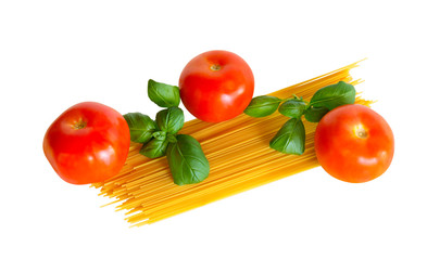 Raw spaghetti pasta with fresh tomatoes and basil leaves isolated on white background